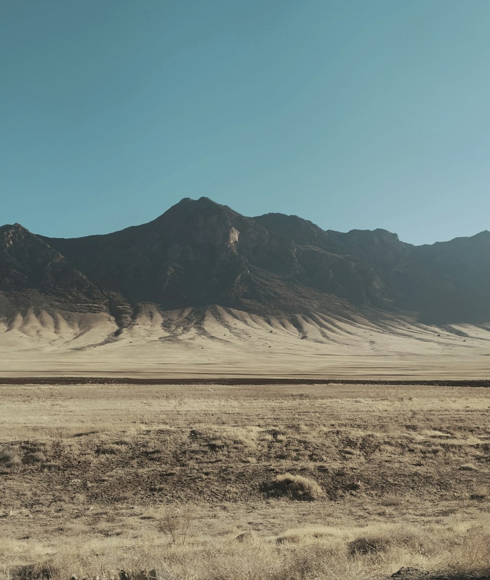 Montañas marrones y grises bajo el cielo azul durante el día