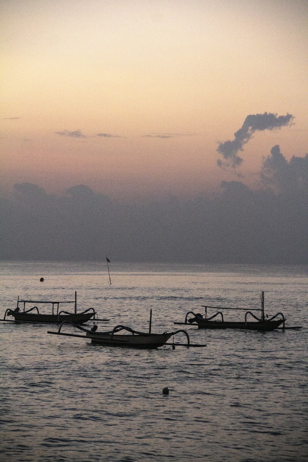 silhouette of people riding on boat on sea during sunset