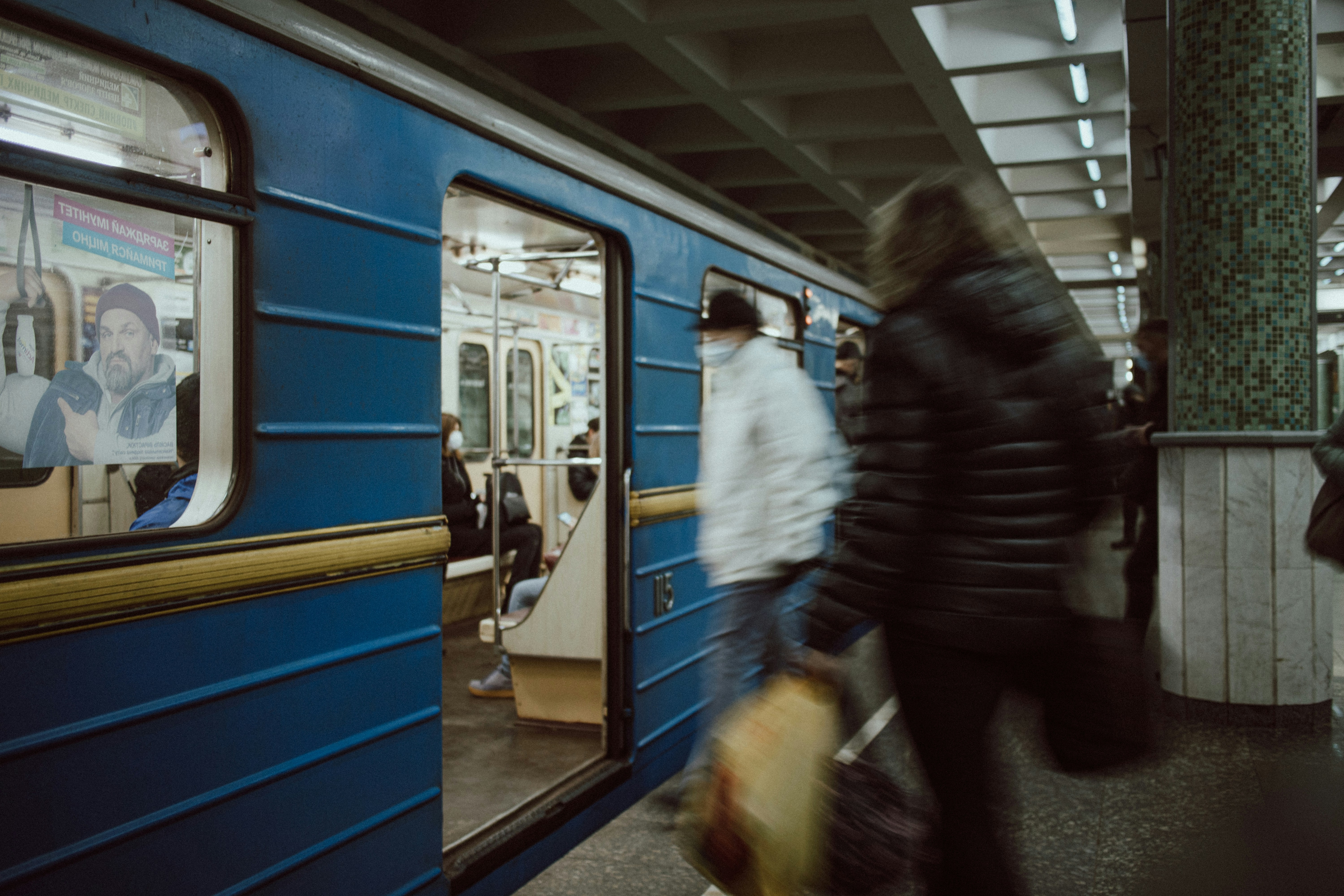 man in black jacket standing beside train