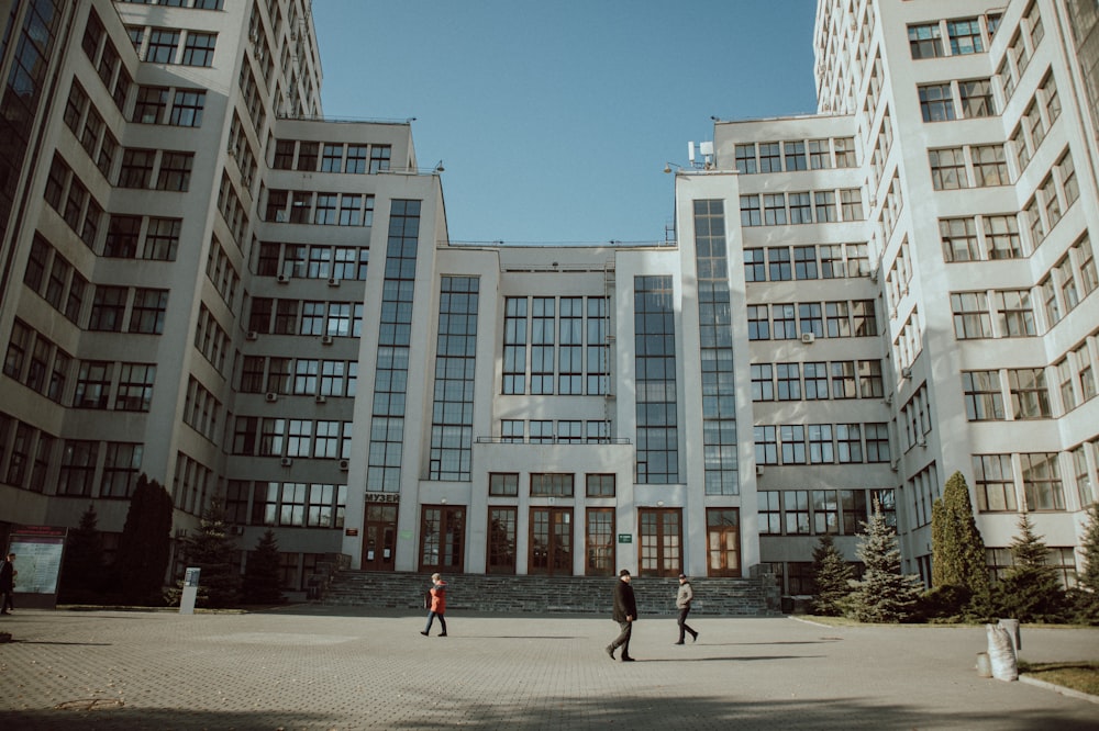 people walking on street near white concrete building during daytime