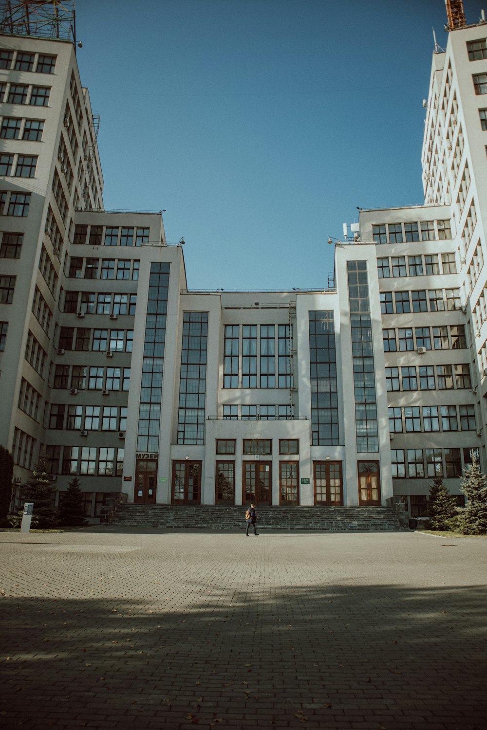 une personne debout devant un grand bâtiment