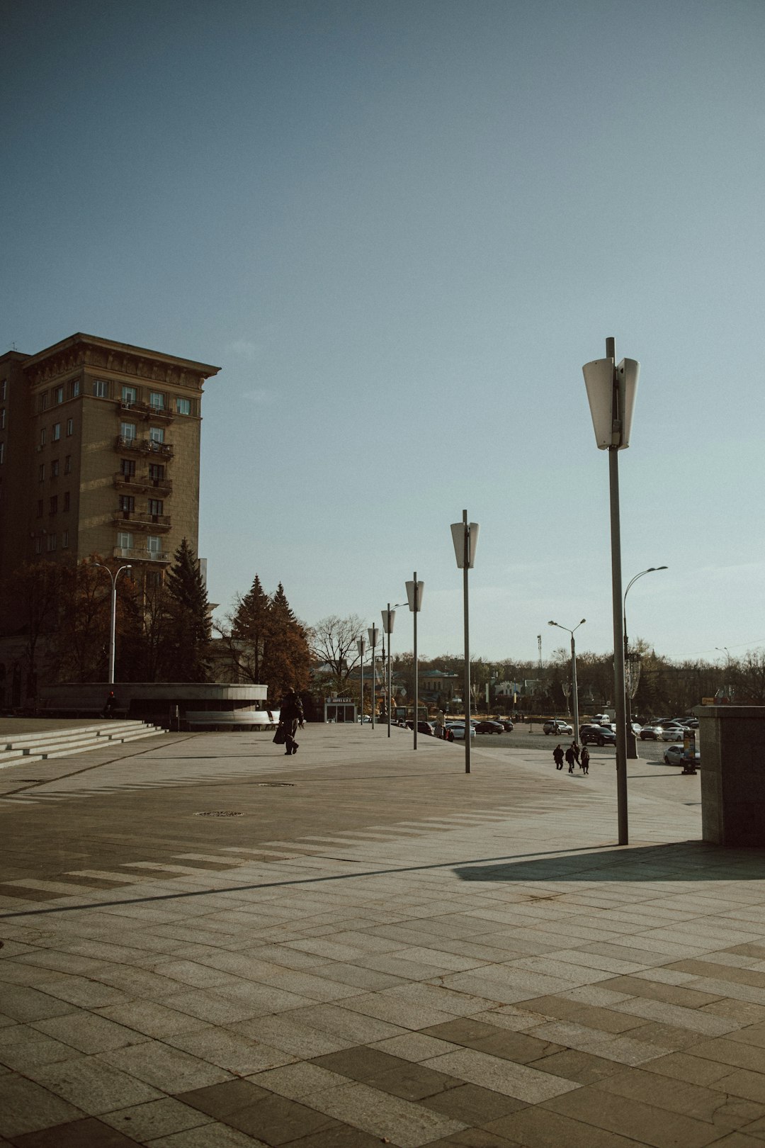 people walking on sidewalk near brown concrete building during daytime