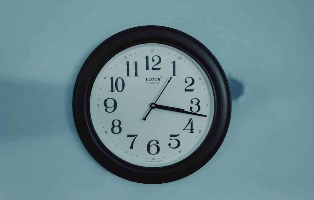 black round analog wall clock at 10 00