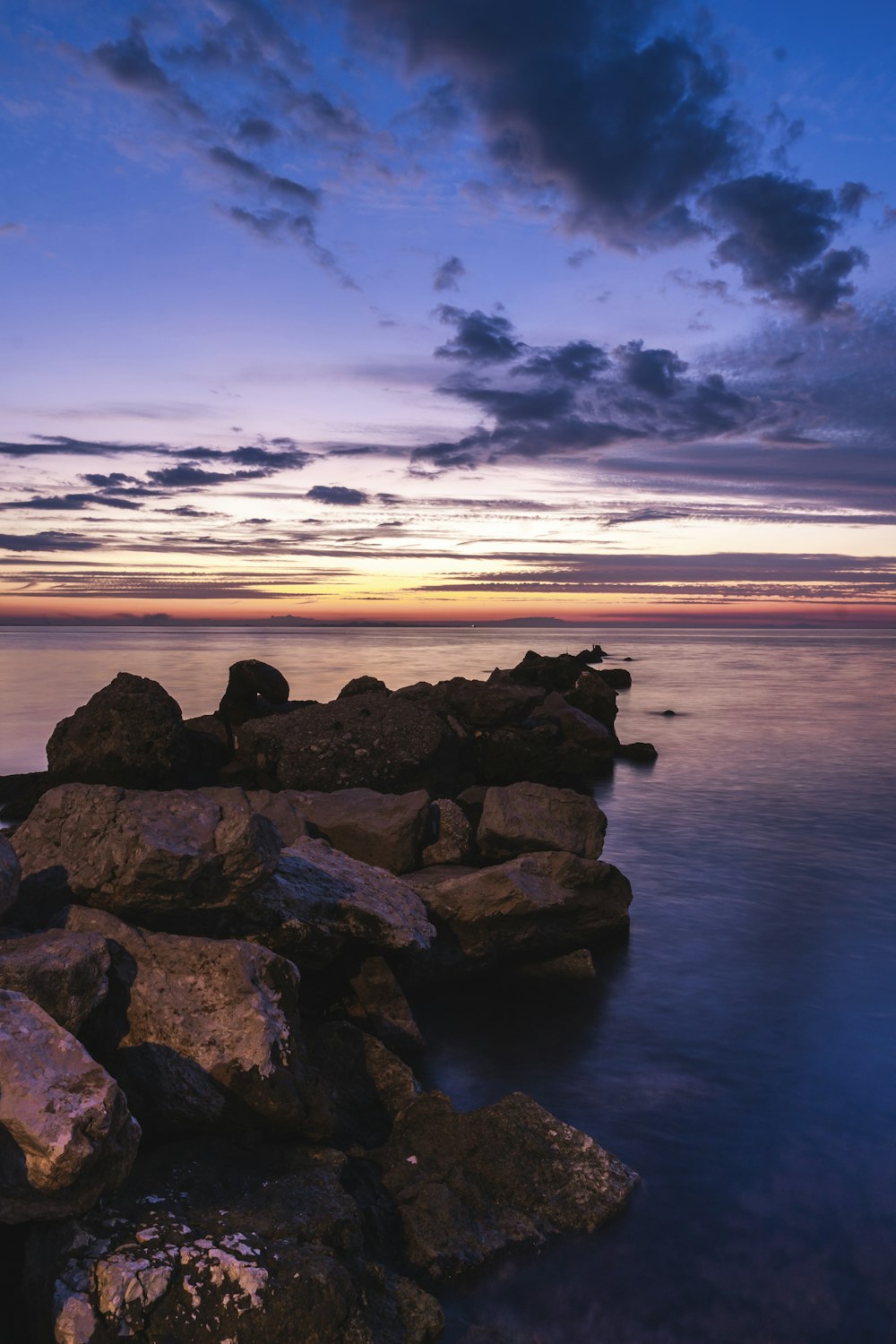 roches brunes sur le bord de la mer au coucher du soleil