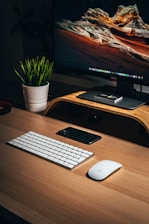 black samsung flat screen computer monitor beside white apple keyboard
