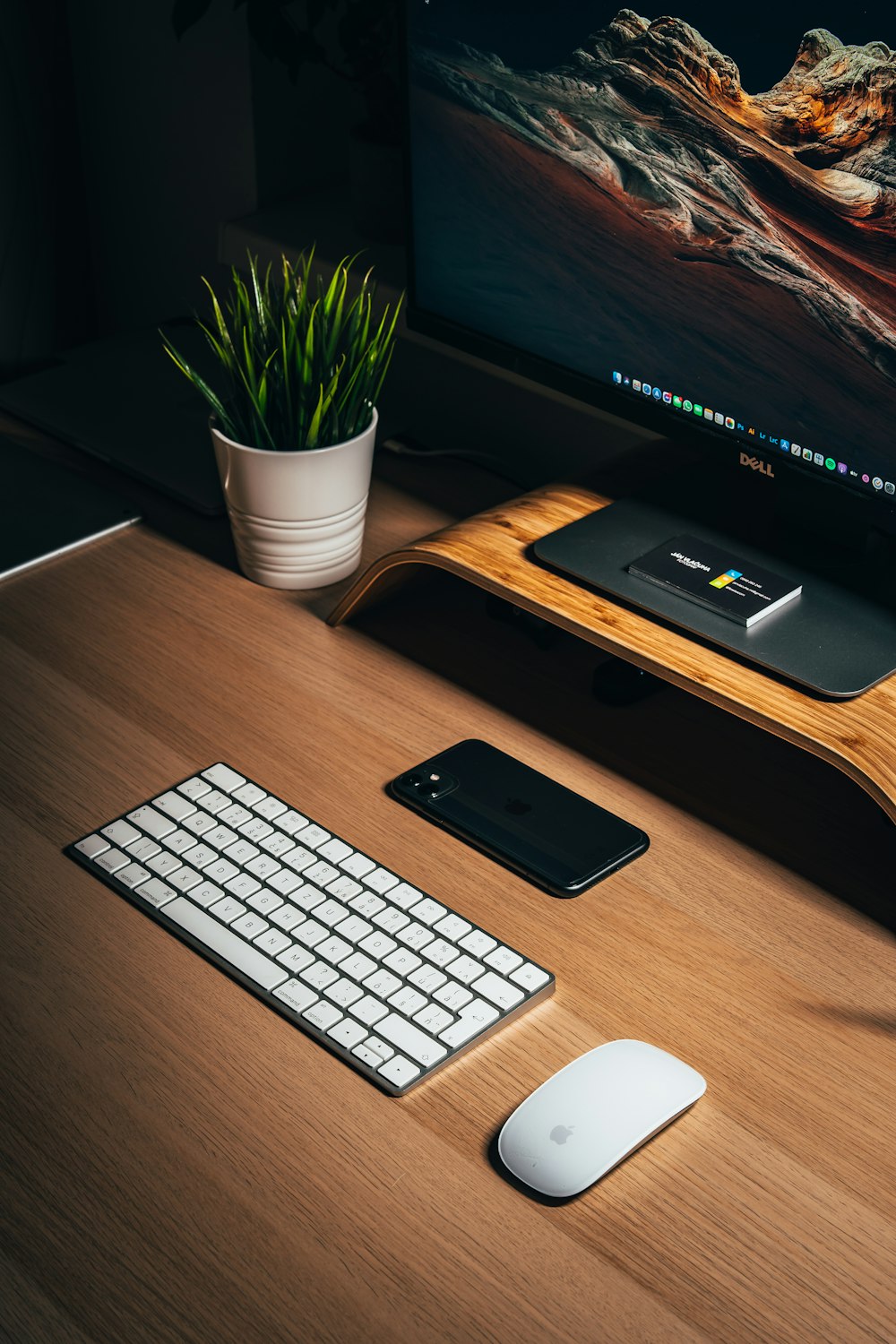 iPhone 5 nero accanto alla tastiera Apple bianca sulla scrivania di legno marrone
