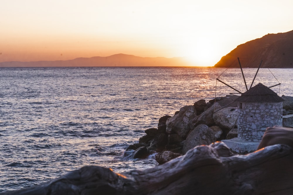 black rocks on sea during sunset