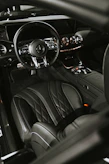 Luxurious car interior with leather seats being gently cleaned by a professional using premium tools.