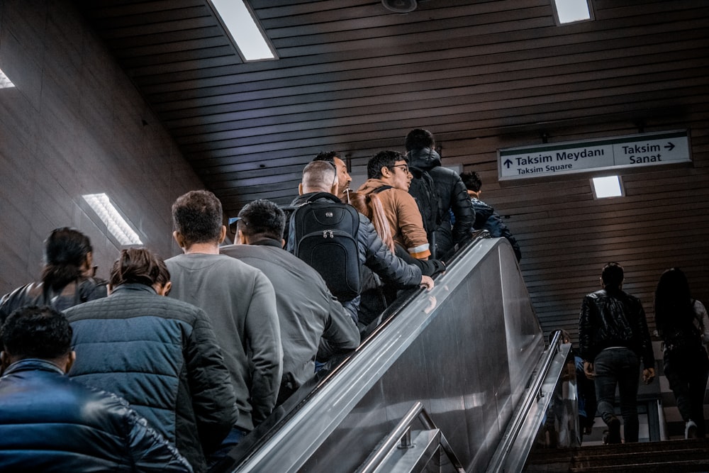 man in black jacket standing on escalator