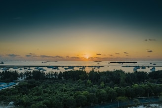 A serene sunset over a calm ocean with a luxury yacht anchored nearby, inviting travelers to unwind.