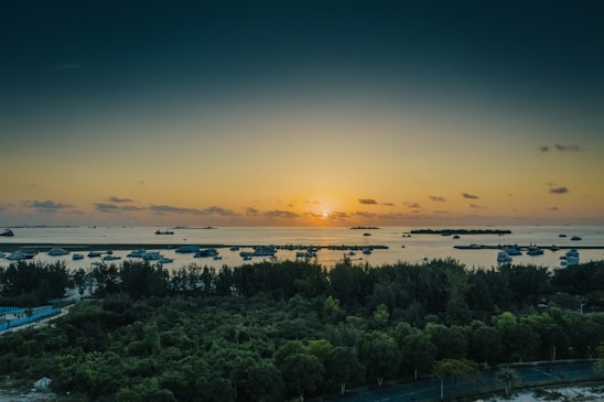 A serene sunset over a calm ocean with a luxury yacht anchored nearby, inviting travelers to unwind.