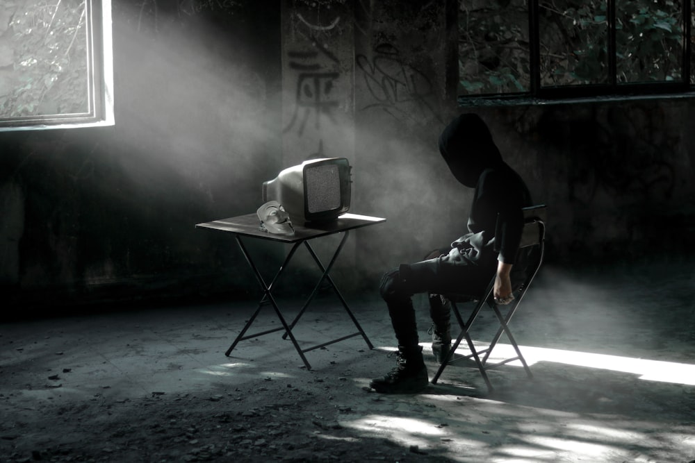 man in black jacket sitting on chair