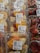 Plastic containers hold mixed fruit slices such as pineapples, oranges, and grapes, next to packages of fresh strawberries. Price labels indicate the cost per kilogram and emphasize immediate consumption.