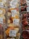 Plastic containers hold mixed fruit slices such as pineapples, oranges, and grapes, next to packages of fresh strawberries. Price labels indicate the cost per kilogram and emphasize immediate consumption.