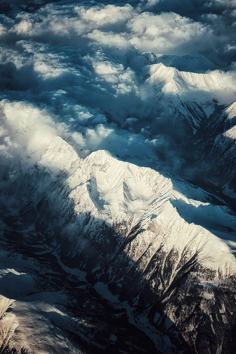 Montagne couverte de neige sous un ciel nuageux pendant la journée