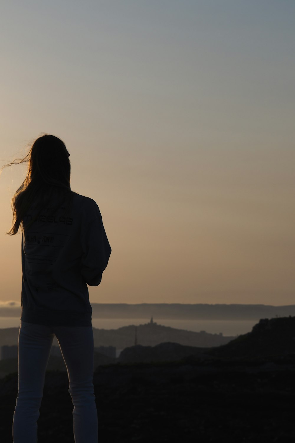 woman in gray jacket standing on top of mountain during daytime