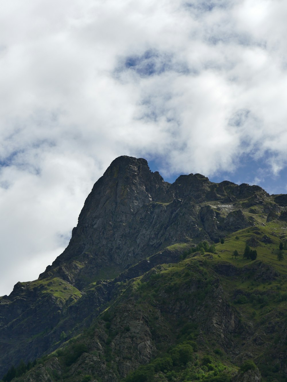 montanha cinzenta e verde sob nuvens brancas durante o dia