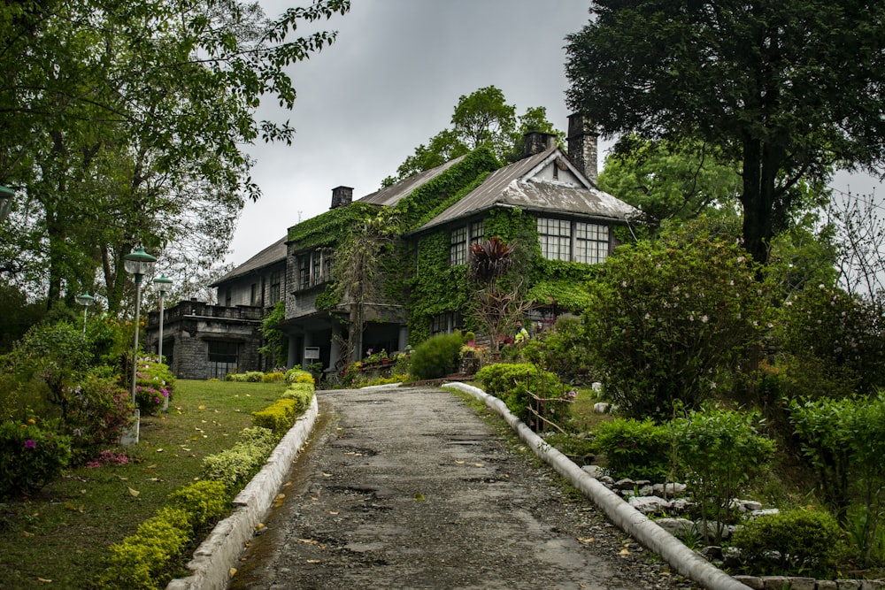 brown and white house near green trees under white clouds during daytime