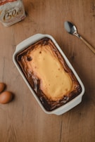 A baker carefully adding the finishing touches to a cheesecake in a cozy kitchen setting.