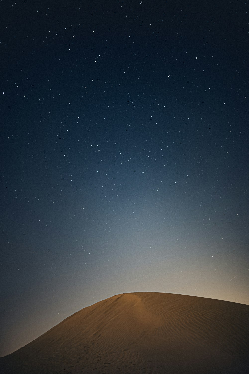 brown sand under blue sky during night time