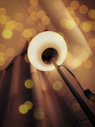 Close-up of a warm LED floor lamp casting soft light in a living room corner.