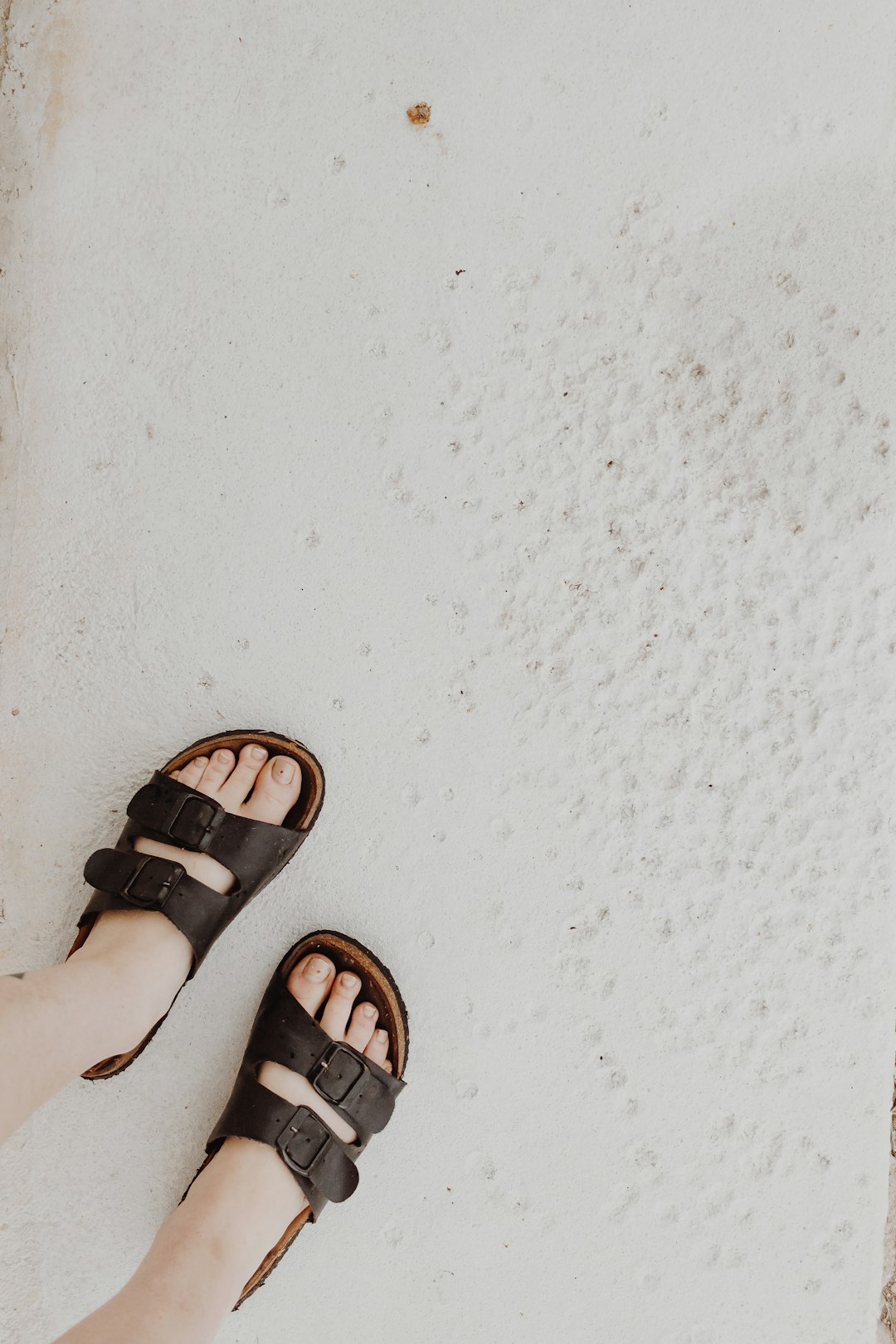 person wearing black leather sandals