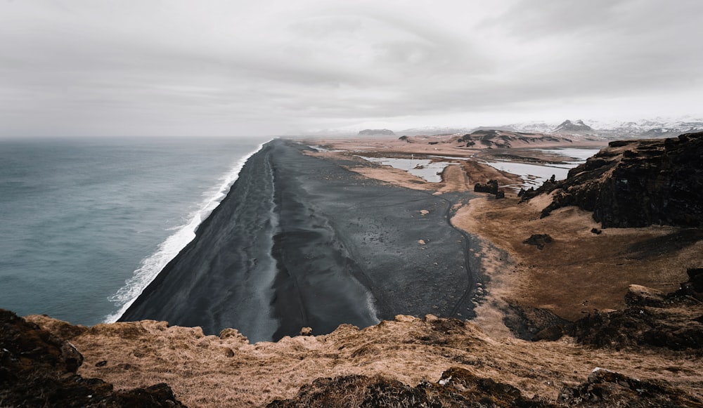 brown rock formation near body of water during daytime