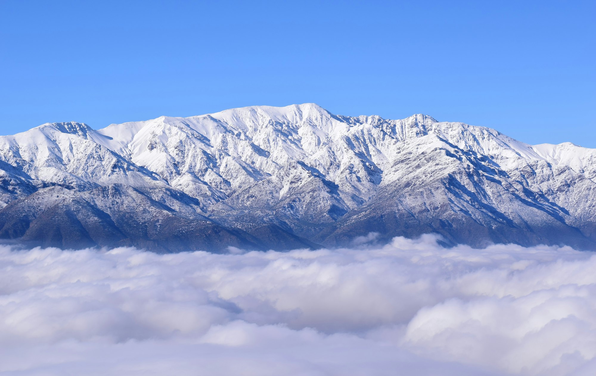 The Andes Mountains peer through clouds