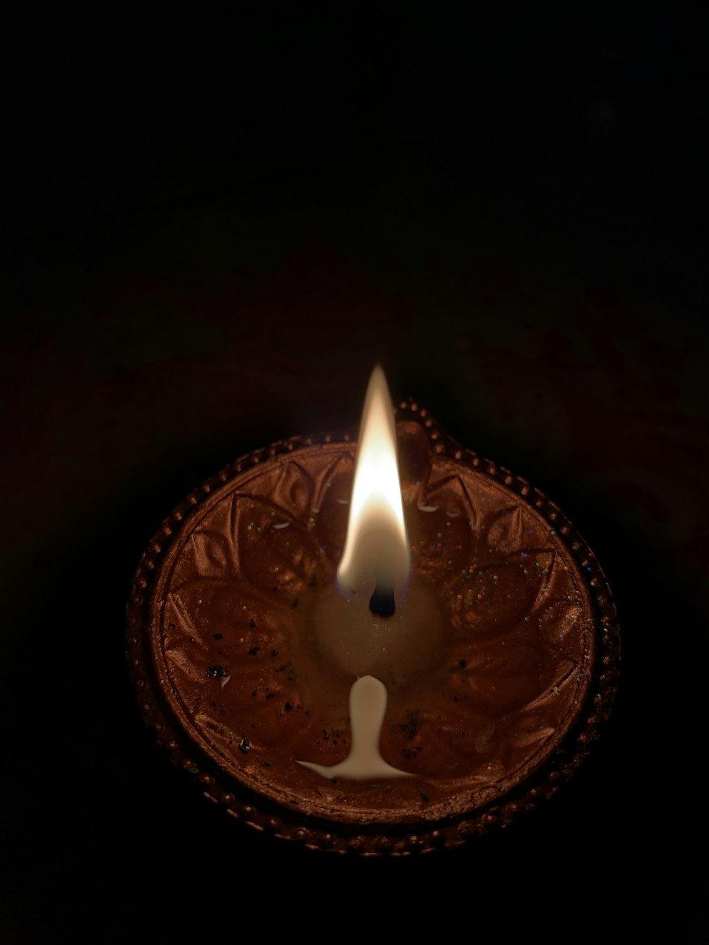 lighted candle on brown round holder