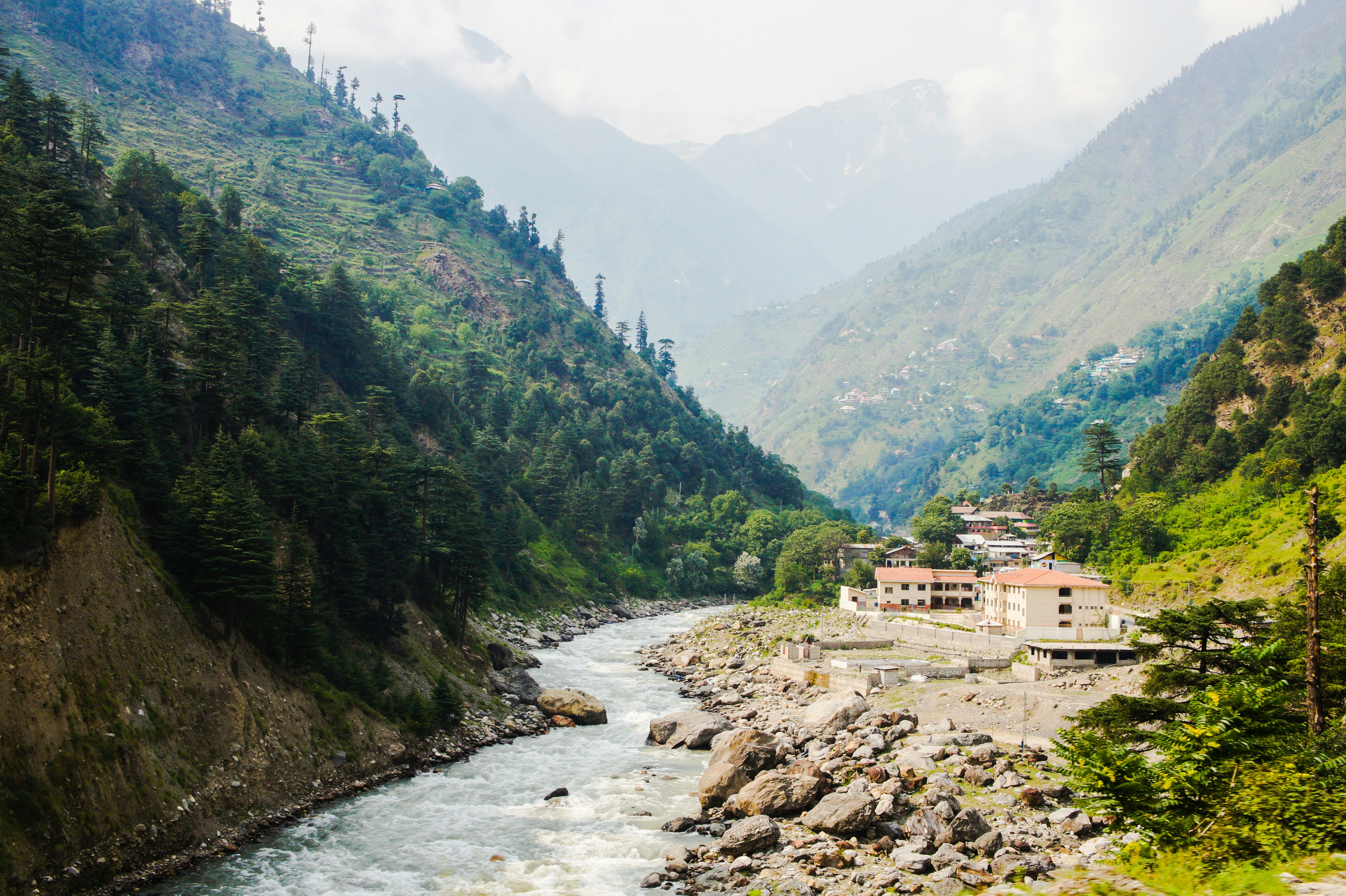 river between green mountains during daytime