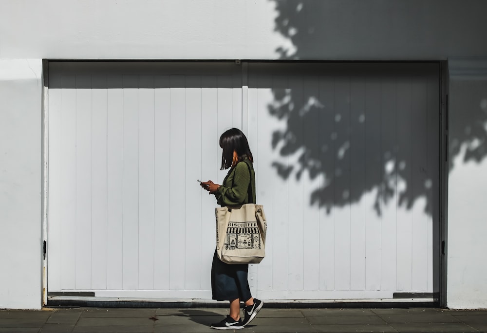 man in black jacket and brown backpack standing on gray pavement