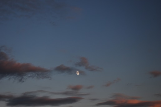 A serene night sky with a glowing full moon casting gentle light over a quiet chapel.