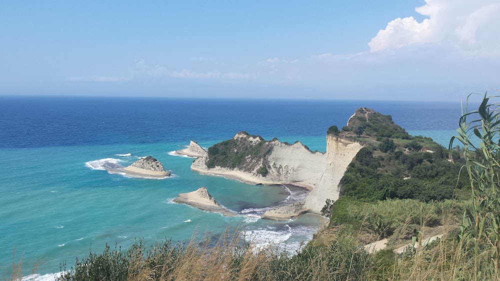 brown rock formation on blue sea under blue sky during daytime