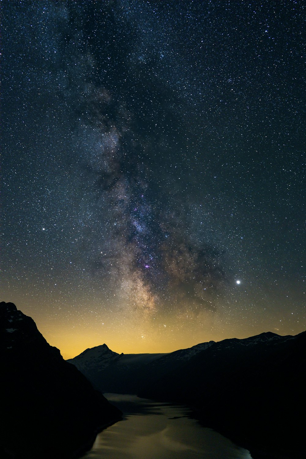 silhouette of mountain under starry night