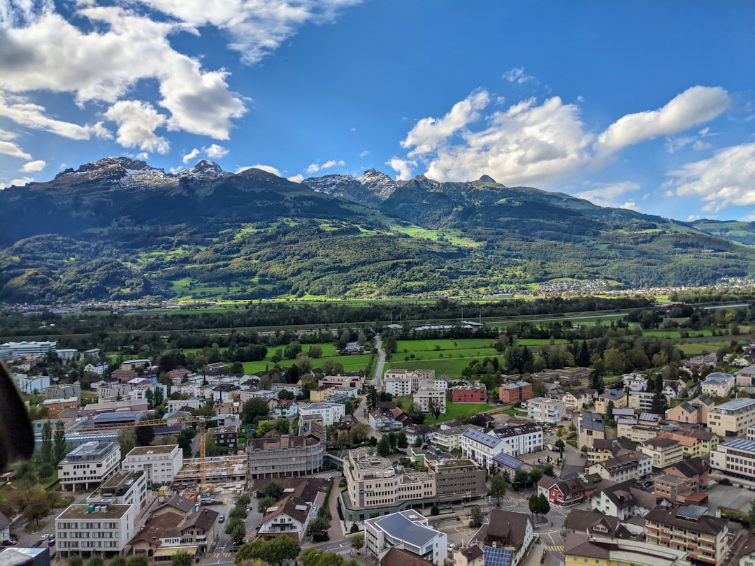 aerial view of city buildings and green mountains during daytime