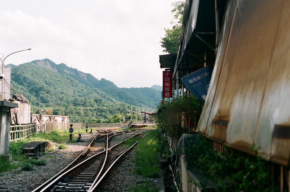 train rail near green mountain during daytime