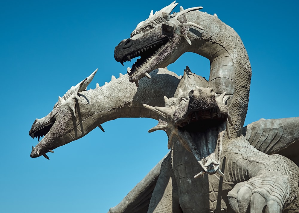 Estatua del dragón gris bajo el cielo azul durante el día