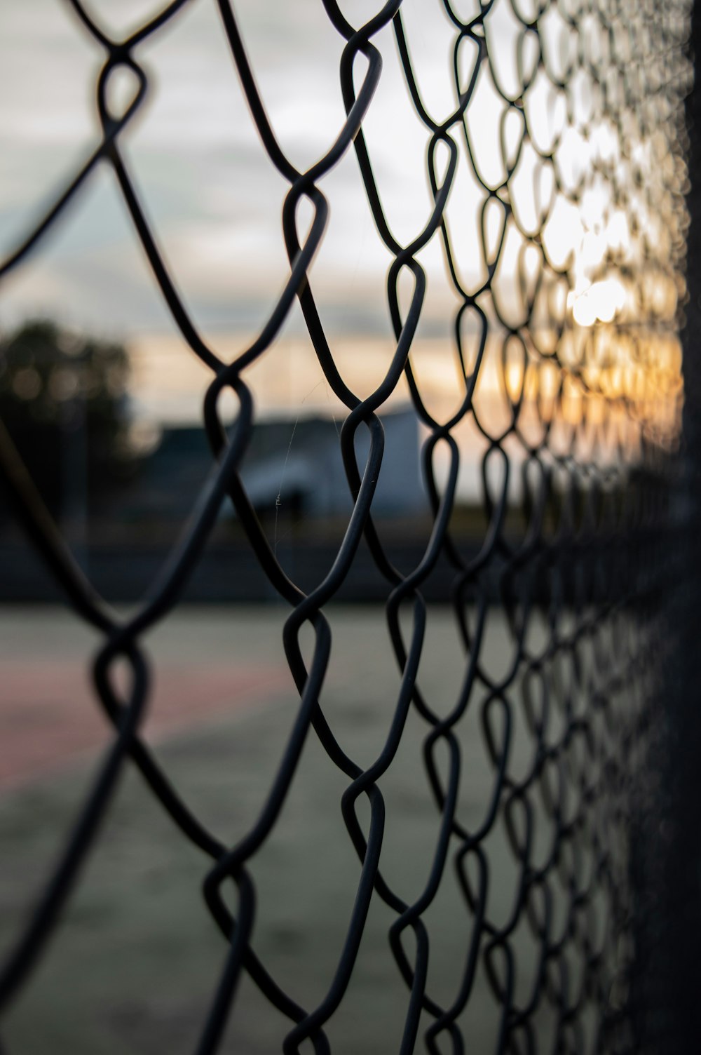 grey metal fence near green grass field during daytime