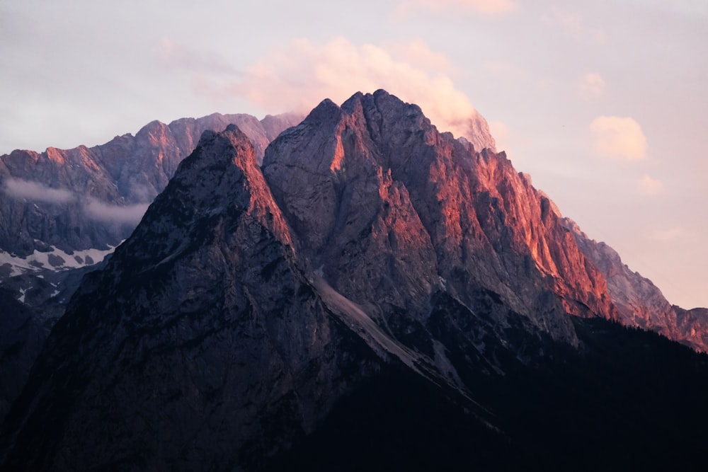 a very tall mountain with some clouds in the sky