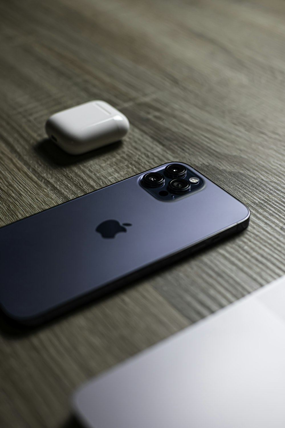 blue and black apple device on brown wooden table