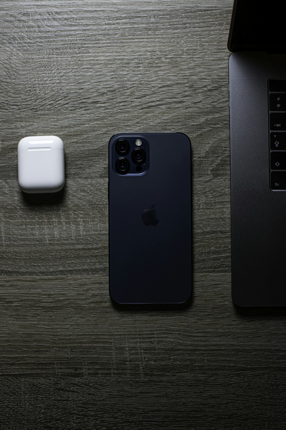 blue iphone case beside white apple airpods charging case