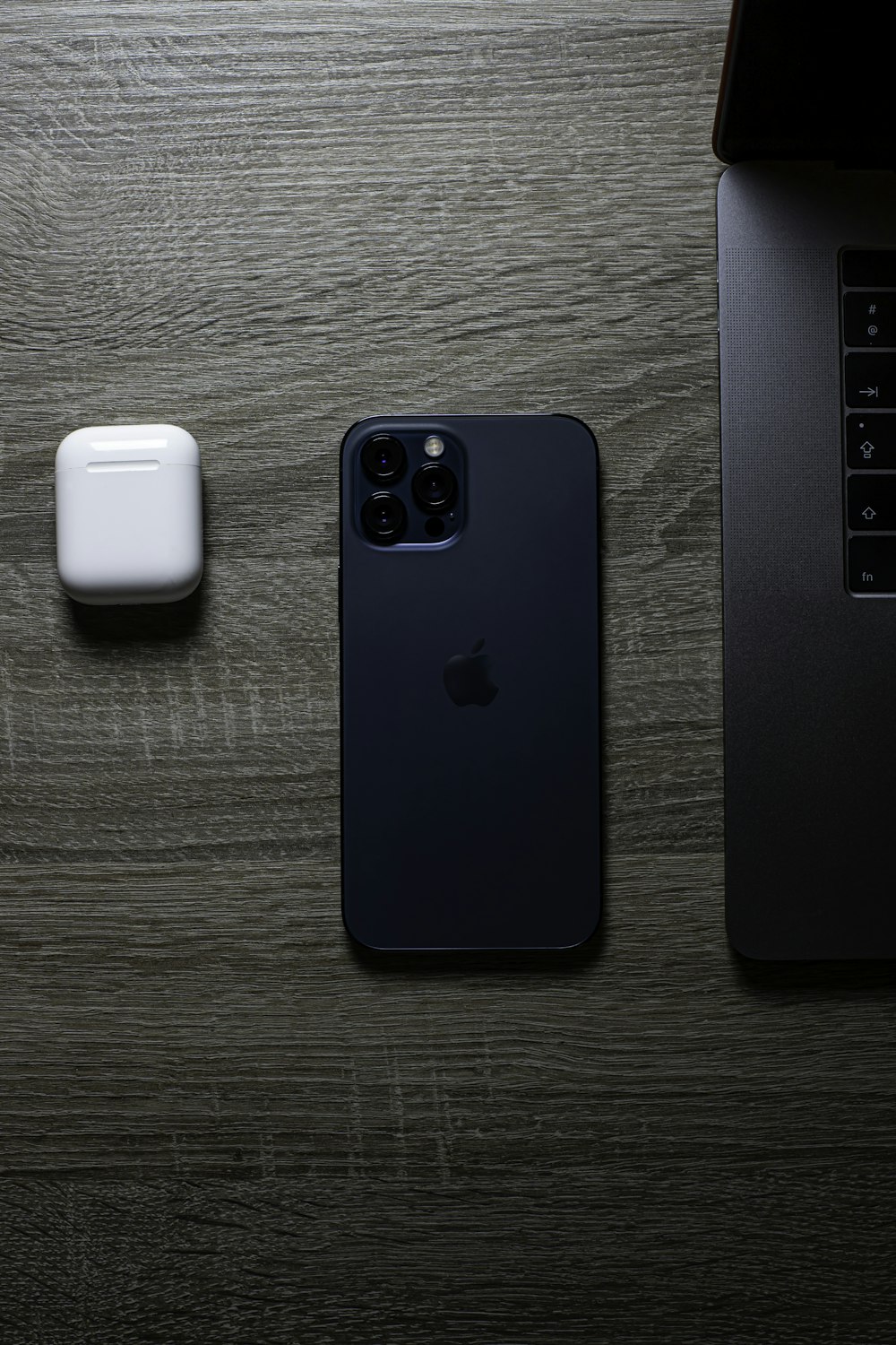 Funda azul para iPhone junto a la funda de carga blanca de Apple AirPods