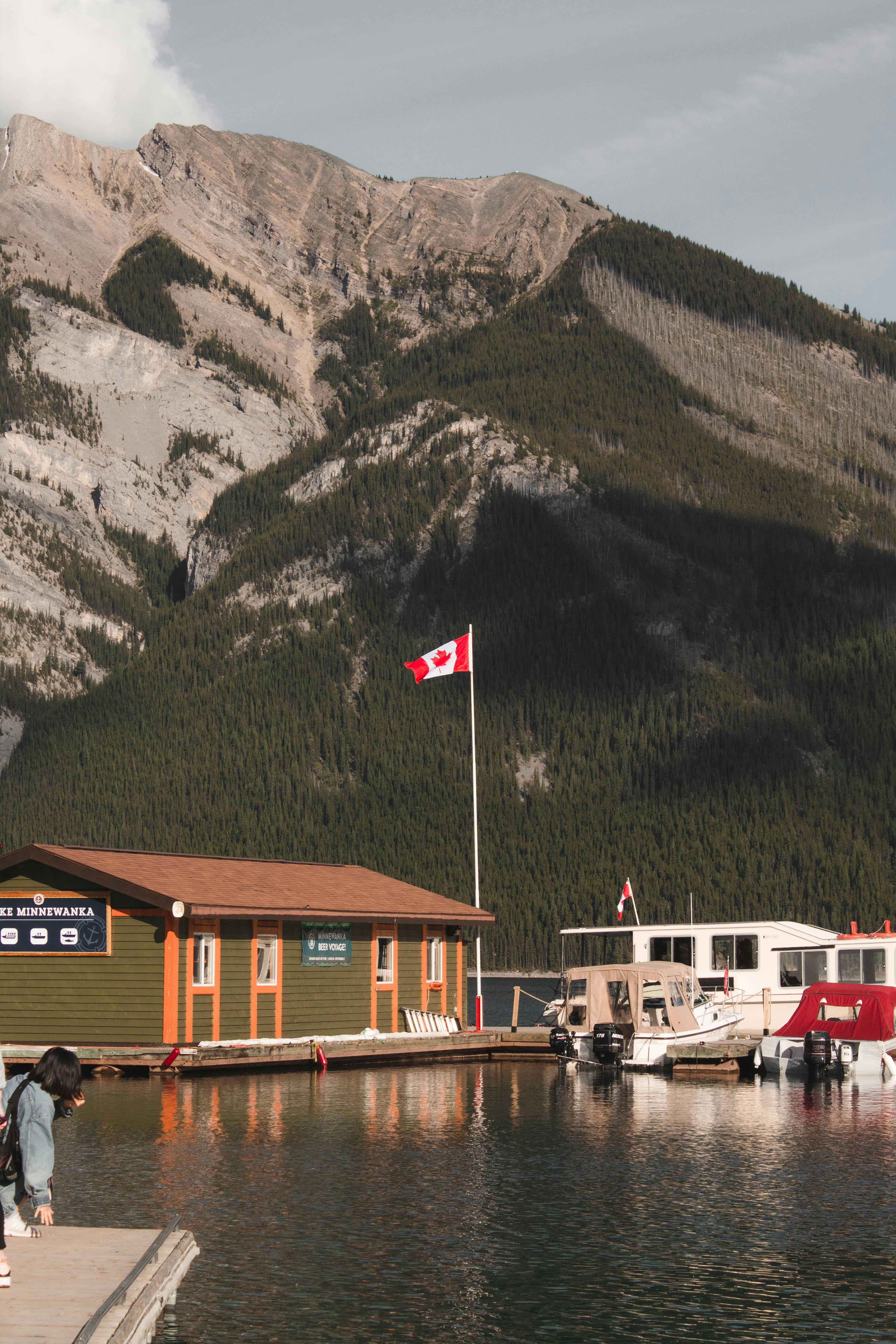 white and brown boat on dock near mountain during daytime