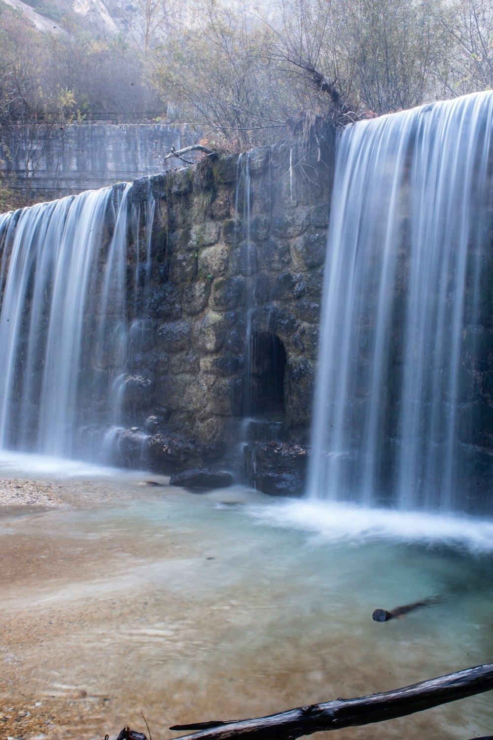 water falls in the middle of gray rocks