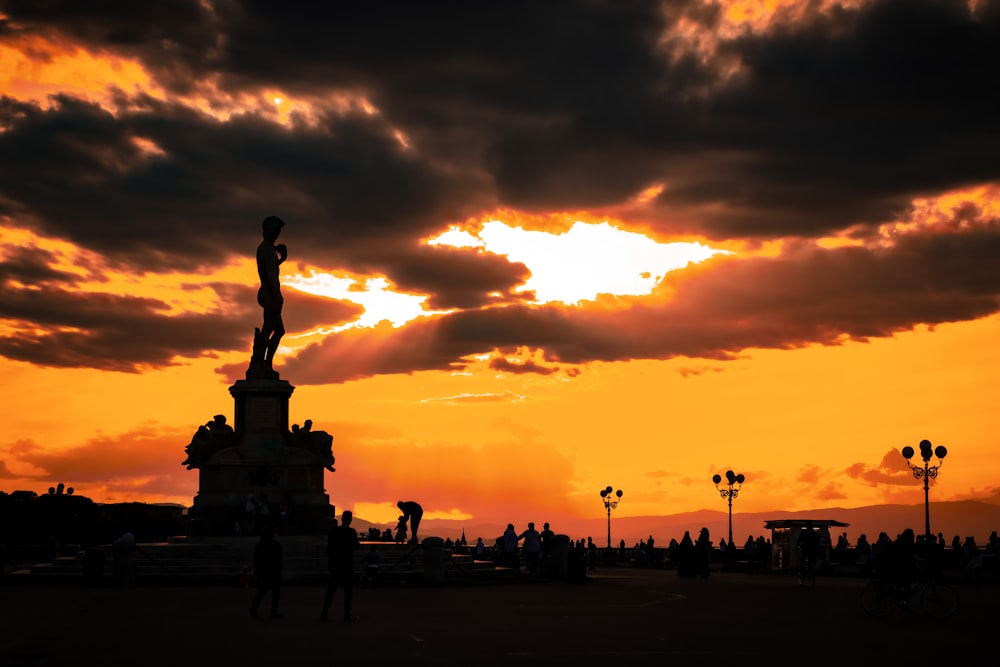 Silueta de la gente que camina por la calle durante la puesta del sol