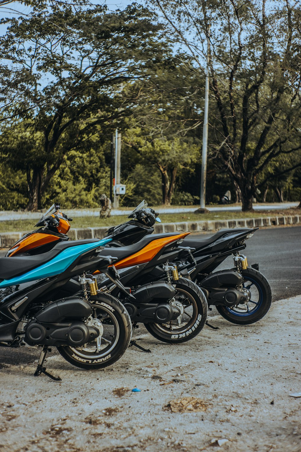 orange and black sports bike parked on gray concrete road during daytime