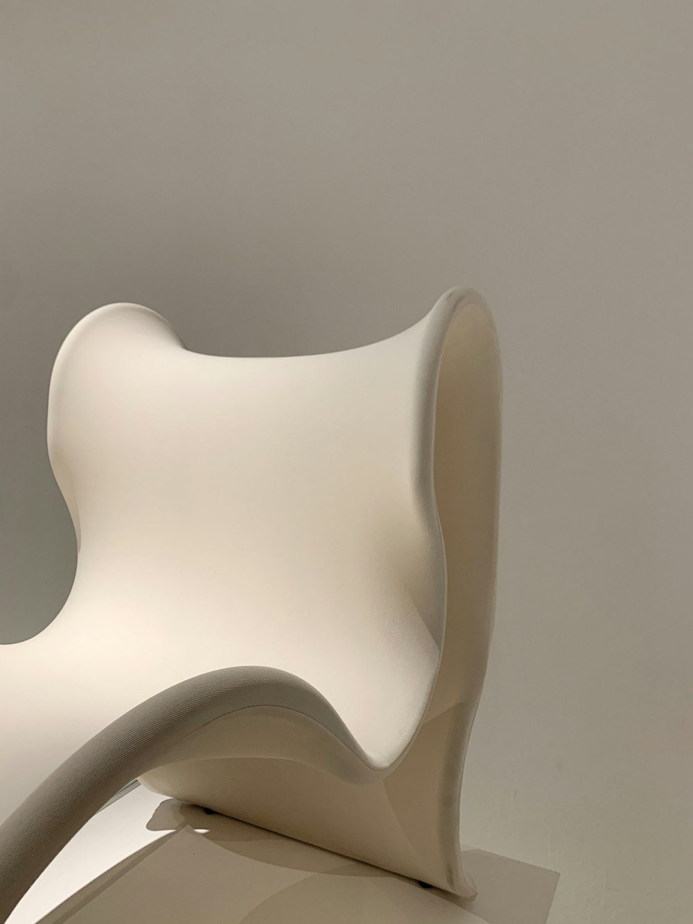 white plastic chair on white surface
