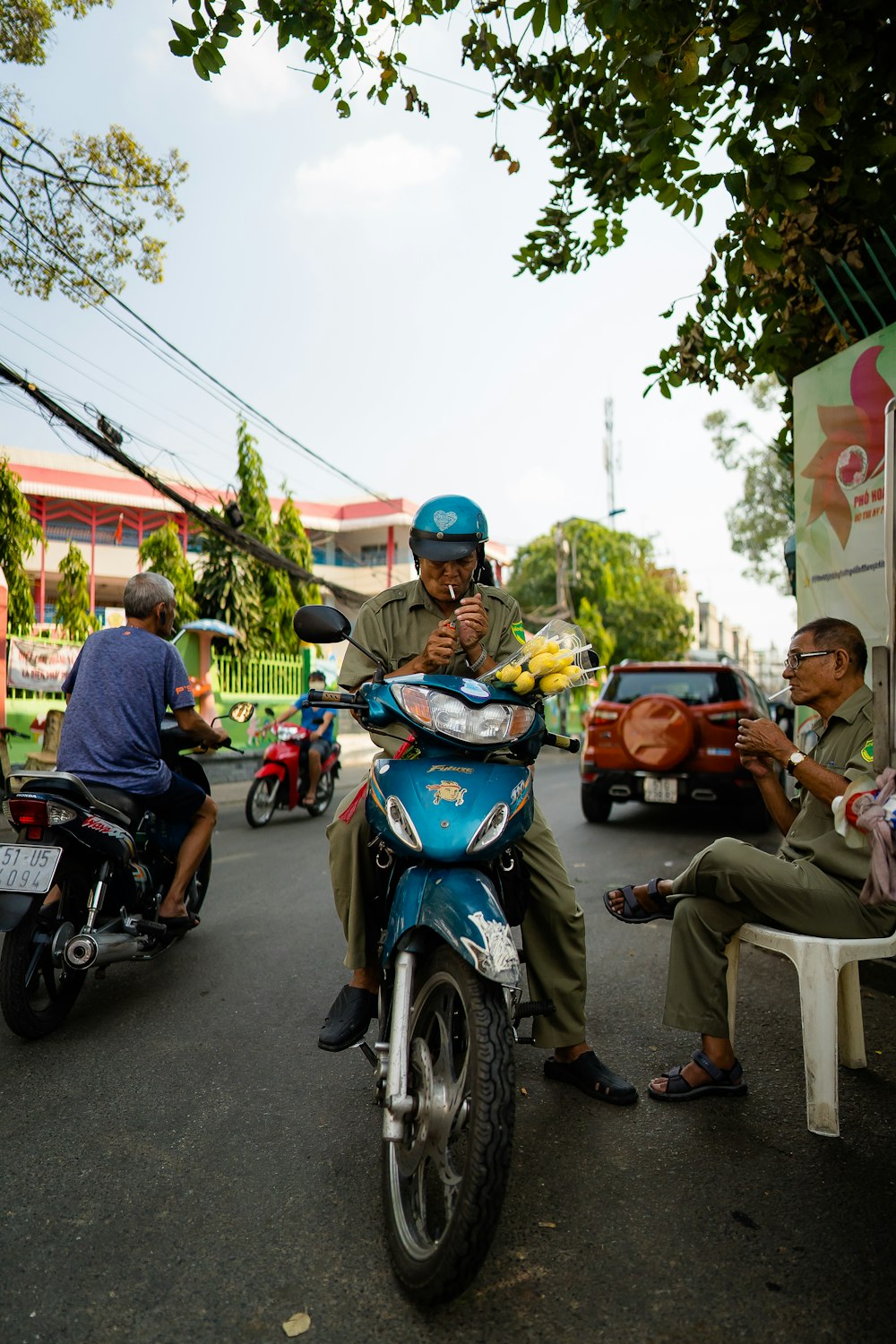 people riding on blue and black motor scooter during daytime