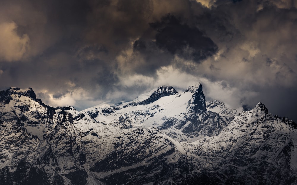 snow covered mountain under cloudy sky during daytime