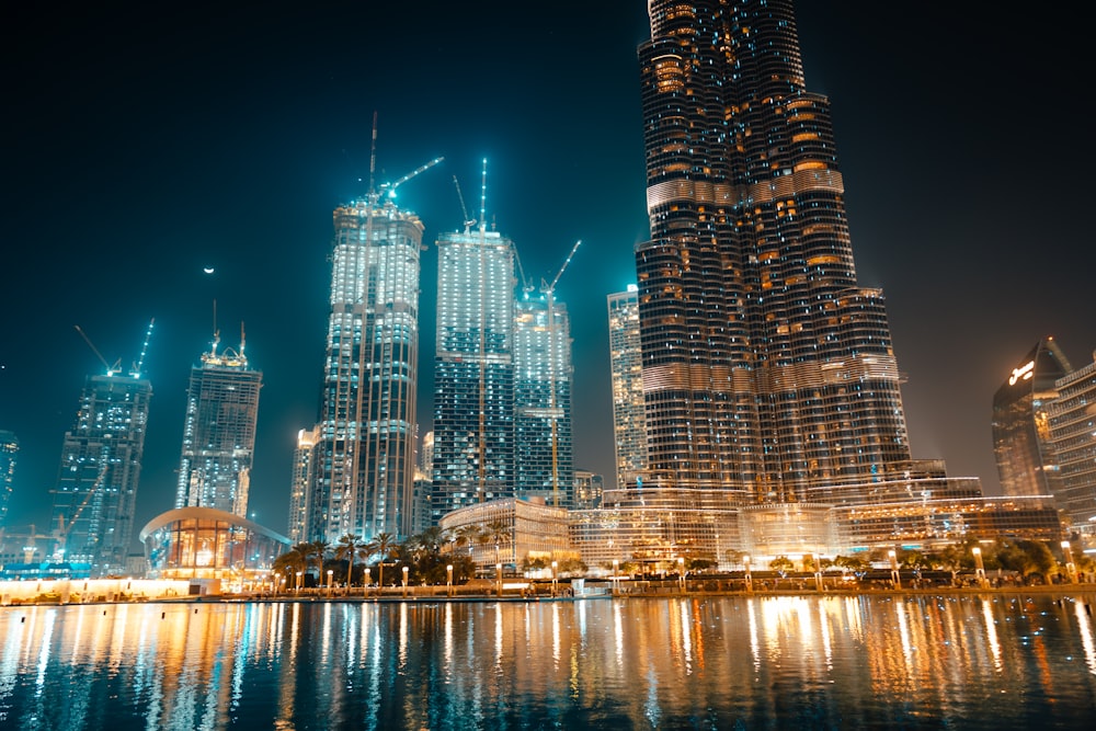 city skyline across body of water during night time